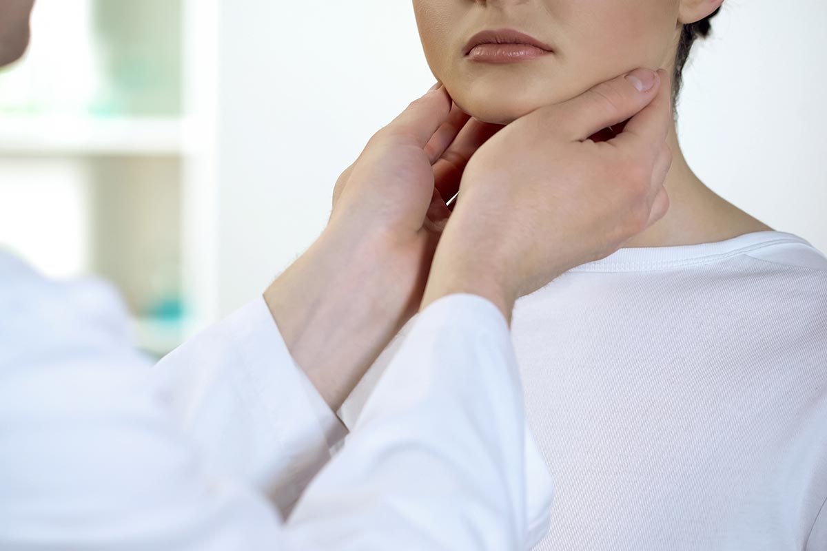 Physician checking patient throat and neck Gateway ENT St Louis MO